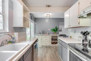 una cocina con encimeras blancas y armarios blancos en Game, Swim and Explore Family Home in Pensacola, en Pensacola