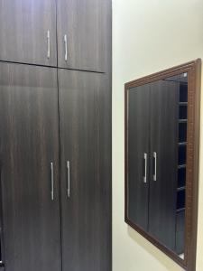 a mirror next to a closet with wooden cabinets at ILHAM SUITEs in Abuja +2 photos