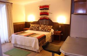 a bedroom with a bed and a chair in a room at Hotel Rucaitue in Osorno