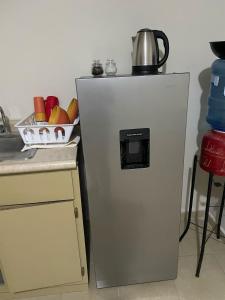 a refrigerator with a tea kettle on top of it at Departamento en Hermosillo in Hermosillo