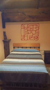 a bedroom with a wooden bed with a sign on the wall at Hostel Casa De Yagil in San Cristóbal de Las Casas