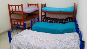 a room with three bunk beds and a mattress at Pequeño Complejo Pachamama - Casa Sol in San Antonio