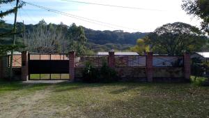 a brick fence with a gate in a yard at Pequeño Complejo Pachamama - Casa Sol in San Antonio