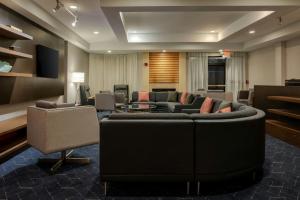 a living room with a large couch and chairs at Courtyard by Marriott North Charleston Airport Coliseum in Charleston