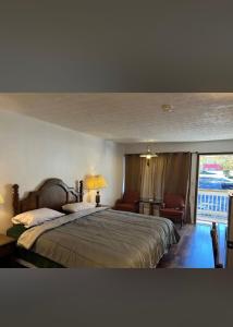 a bedroom with a large bed and a balcony at Lemon Inn in Spruce Pine