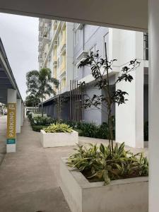 a walkway with a row of plants next to a building at Our Space in CasaMira Towers Mandaue Cebu in Mandaue City