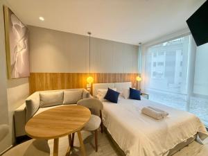 a bedroom with a large bed and a table at Suite Ejecutiva de Lujo 2 personas, Wi-Fi, cafetera, GYM, Jacuzzy, a 3 minutos del Parque La Carolina in Quito