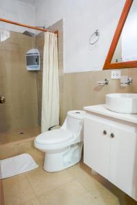 a bathroom with a white toilet and a sink at Royal Galápagos Inn in Puerto Baquerizo Moreno