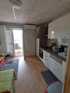 a kitchen with white cabinets and a counter top at Apartments with parking space Lopar, Rab - 5019 in Lopar