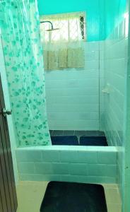 a bathroom with a shower with a blue shower curtain at South Oasis in Georgetown +9 photos