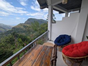 balcón con sillas y vistas a las montañas en Rock Paradise Homestay, en Ella
