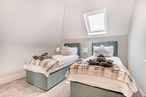 サウスボーンにあるSOBO Loft Sleek Southbourne 2-Bedroom Apartment Close to SOBO Beachの白い壁のベッドルーム1室(ベッド2台付)