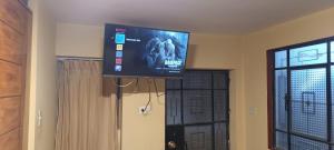 a flat screen tv hanging from the ceiling of a room at Hostal Sumak'usi in Juliaca +14 photos