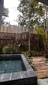 a backyard with a swimming pool and a wooden fence at Pousada Flor de Biriba Trancoso in Trancoso