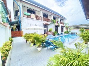 ルアンパバーンにあるLuang Prabang Pavilion Hotel & Travelのパティオ(椅子、パラソル、プール付)