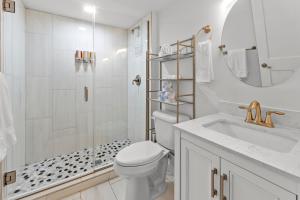 a white bathroom with a toilet and a sink at Modern Home w/Garage Near SLU | JZ Vacation Rentals in Soulard +30 photos