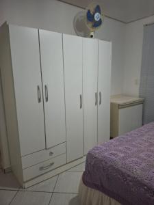 a bedroom with white cabinets and a purple bed at Edifício Vitória 1 Apt 501 in Marcelino Ramos