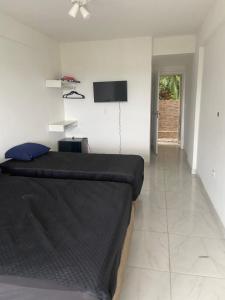 a bedroom with a bed and a flat screen tv at Suites mirante da Enseada in Guarujá