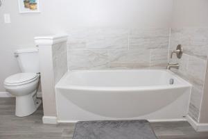 a bathroom with a white tub and a toilet at Lovely 3-Bedroom Duplex in Douglasville