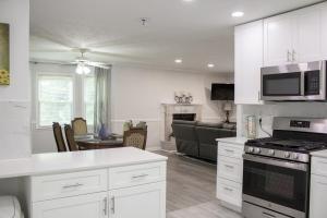 a kitchen with white cabinets and a living room at Lovely 3-Bedroom Duplex in Douglasville