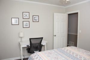 a bedroom with a bed and a desk and a chair at Lovely 3-Bedroom Duplex in Douglasville +39 photos