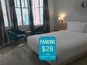 a hotel room with a bed and a sign that says parking tax subject at Touchstone Hotel - City Center in San Francisco