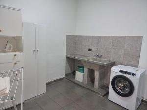 a laundry room with a washing machine and a sink at La casa de Flor in San Martín