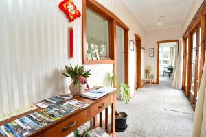 a hallway with a desk with books and a window at Sunny Mornington 2 Bedroom Guest Suite in Dunedin