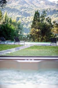 three benches in a park with mountains in the background at Auria Angostura in Villa La Angostura +43 photos