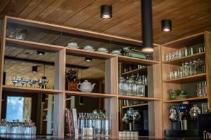 a bar with wooden walls and shelves with glasses at Auria Angostura in Villa La Angostura