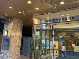 Una entrada a un edificio con un ascensor de cristal. en Toyoko Inn Osaka Honmachi No2, en Osaka