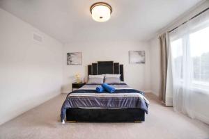 a bedroom with a large bed with blue pillows at Tranquil Lakeside Townhouse in Severn