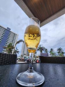 a glass of beer sitting on top of a table at Apto Salinas Exclusive Resort, 2 quartos in Salinópolis