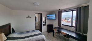 a bedroom with a bed and a large window at Hotel El Eden 4 per 15 in Zacatlán