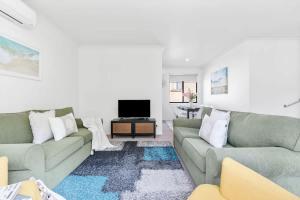 a living room with two couches and a tv at Mollymook Memories - close to beach & golf course in Mollymook
