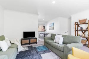 a living room with two couches and a tv at Mollymook Memories - close to beach & golf course in Mollymook