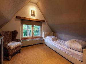 a small attic bedroom with a bed and a window at Holiday home with 3 bedrooms in Koksijde