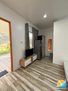 a living room with a television and a refrigerator at Saraswati Exclusive Resort in Esperanza