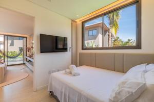 a bedroom with a bed and a large window at JG Flecheiras in Trairi