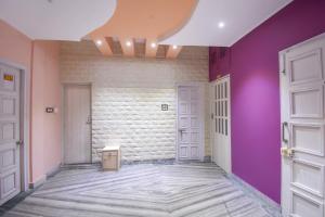 un pasillo con paredes púrpuras y puertas blancas en Hotel O RS Guest House, en Calcuta