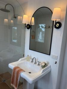 un bagno bianco con lavandino e specchio di Gorgeous Country Cottage In Lovely Private Grounds a Scone