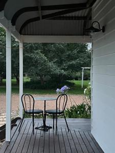 un tavolo e due sedie su un portico di Gorgeous Country Cottage In Lovely Private Grounds a Scone