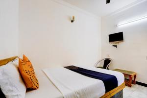 a bedroom with a bed and a tv on the wall at SPOT ON JAYAM RESIDENCY in Chennai +22 photos