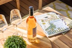 a bottle of wine sitting on a table with glasses at Baramook - family home with golf & beach nearby in Mollymook