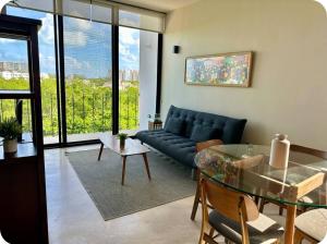 a living room with a blue couch and a glass table at Mangle 13 Modern Apartments-Rooftop pool, close to Ferry in Cancún