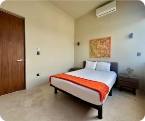 a bedroom with a bed with a red blanket at Mangle 13 Modern Apartments-Rooftop pool, close to Ferry in Cancún +36 photos