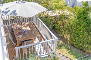 a wooden table with an umbrella on a deck at Whalers Retreat - Hyams Beach 3BR cottage in Hyams Beach +35 photos