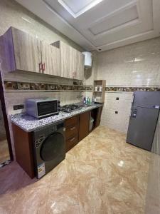 a kitchen with a stove and a microwave in it at maison de bonheur 2 in Tafraoute