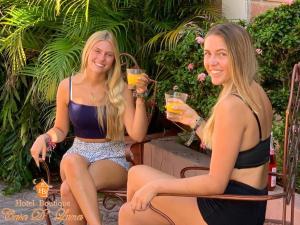 two women in bathing suits holding glasses of orange juice at Hotel Boutique Casa D' Luna in Choluteca