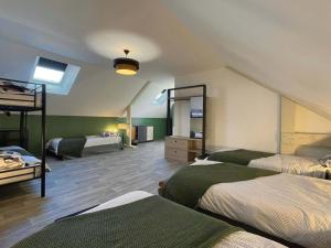 a room with three beds in a room with at Gîte spacieux dans le Perche avec WIFI inclus, idéal pour réunions familiales - FR-1-497-240 in Val-au-Perche